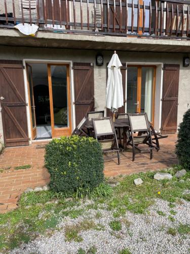 a patio with a table and chairs and an umbrella at Appartment tourmalet in Campan
