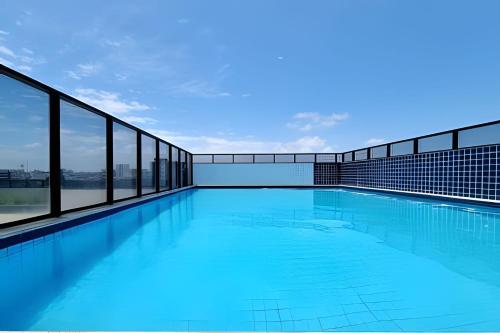 a swimming pool with blue water and windows at Apê à 5min da Praia com Piscina na Coberftura in Maceió