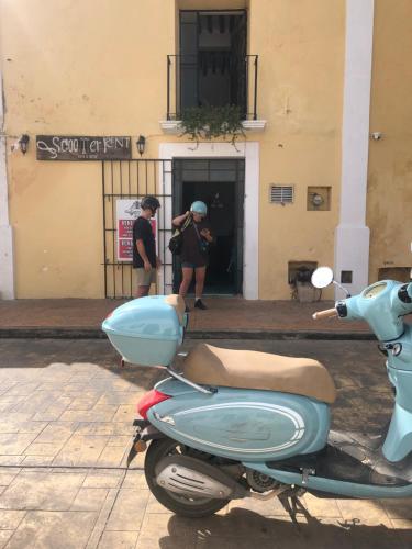 a scooter parked in front of a building with two people at casa pich balam in Valladolid