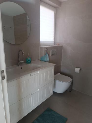 a bathroom with a sink and a toilet and a mirror at בריזה במדבר in Idan