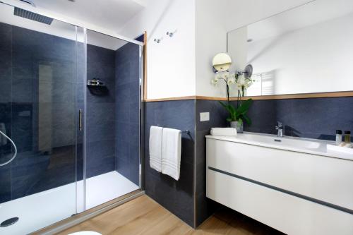 a bathroom with a white sink and a shower at Solymar Suite in Sorrento