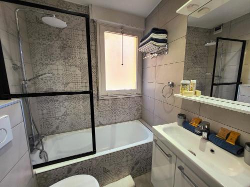 une salle de bain avec une baignoire, des toilettes et un lavabo dans l'établissement Charmant 2 pièces, traversant, clim, wifi, parking, à Cannes
