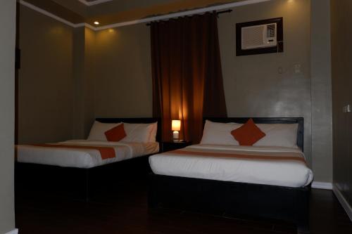two beds in a hotel room with at Vela Terraces Hotel in Coron