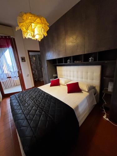 a bedroom with a large bed with two red pillows at La Casa di Pablo B&B in Ferrara