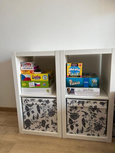 a book shelf with books and other books at Apartmán se slunnou teráskou v Kašperkách in Kašperské Hory