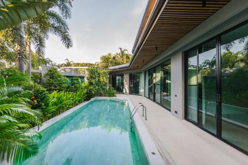 an indoor swimming pool in the backyard of a house at Ban Bua Lux x MonthStayz Thailand in Rawai Beach