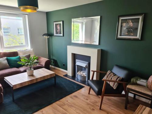 a living room with a couch and a fireplace at Modern 2 Bed Flat with Parking in Aberdeen
