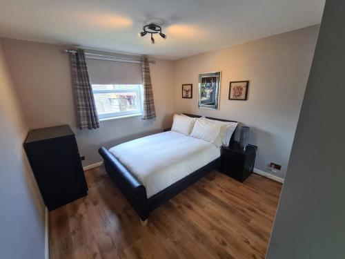 a bedroom with a bed and a window at Modern 2 Bed Flat with Parking in Aberdeen