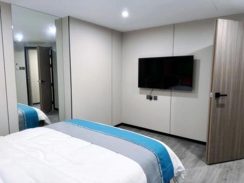 a bedroom with a bed and a flat screen tv at 杏花小筑商务大床房 b in Hong Kong