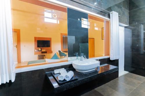 a bathroom with a sink and a large mirror at BA-NA Hills Resort in Salara