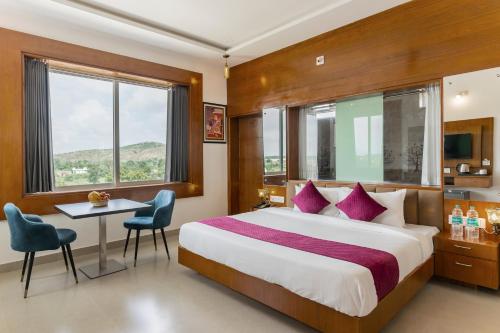 a hotel room with a bed and a table and chairs at BA-NA Hills Resort in Salara