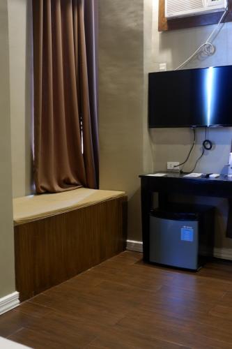 a room with a desk with a computer and a monitor at Vela Terraces Hotel in Coron