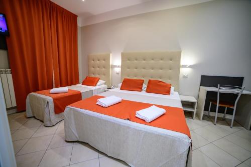 a bedroom with two beds with orange pillows at Hotel Demo' in Milan