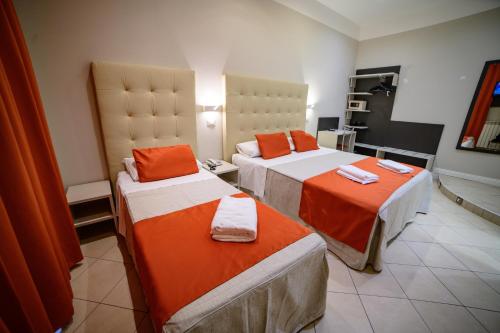 a hotel room with two beds with orange sheets at Hotel Demo' in Milan