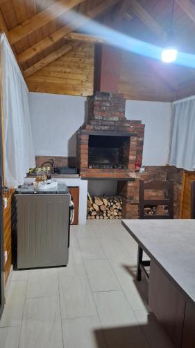 a kitchen with a stove and a stone fireplace at Casuta de la ferma in Băiculeşti