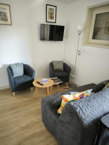 un salon avec un canapé, deux chaises et une table dans l'établissement Apt or chalet near the slopes Megève, à Megève