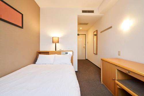 a small bedroom with a bed and a desk at HOTEL GLOBAL VIEW Morioka in Morioka
