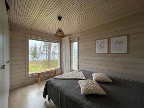 a bedroom with a bed in a room with a window at Auhon sarastus - Dream by a lake in Petäjä