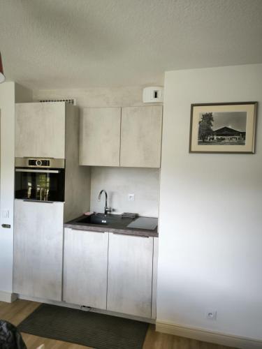 une cuisine avec des armoires blanches et un évier dans l'établissement Apt or chalet near the slopes Megève, à Megève