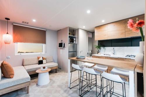 a kitchen and living room with a bar and a couch at Mobil Homes Vacances in Grimaud