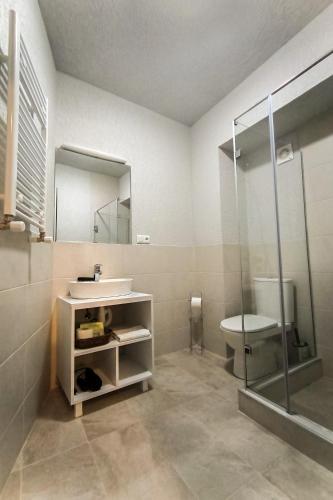 a bathroom with a sink and a toilet and a mirror at Tea for Two Hotel in Tbilisi City