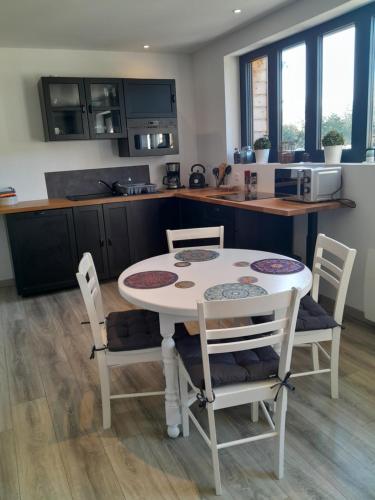 a kitchen with a table and chairs in a kitchen at Au delà des Remparts in Montreuil-sur-Mer
