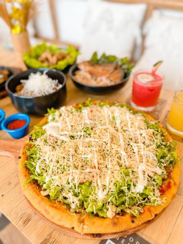 a pizza sitting on top of a wooden table at Vela Terraces Hotel in Coron