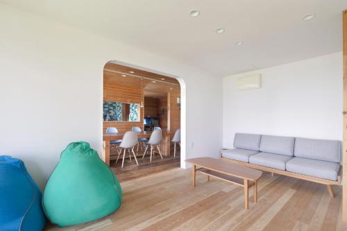 ImabariにあるIncense Beachfront Villaのソファとテーブルのあるリビングルーム