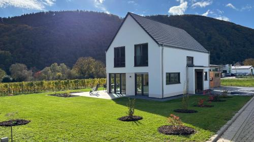 a white house with a garden and mountains in the background at Haus im Weinberg in Ellenz-Poltersdorf