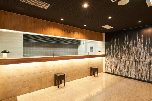 a bar with two stools in a waiting room at Hotel JIN Morioka Ekimae in Morioka