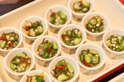 a tray filled with small cups of food on a table at Hotel JIN Morioka Ekimae in Morioka