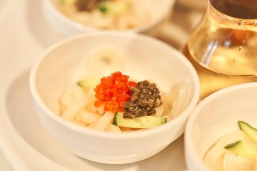 a white bowl of food on a white plate at Hotel JIN Morioka Ekimae in Morioka