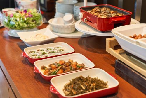 a table topped with trays of food and plates of food at Hotel JIN Morioka Ekimae in Morioka