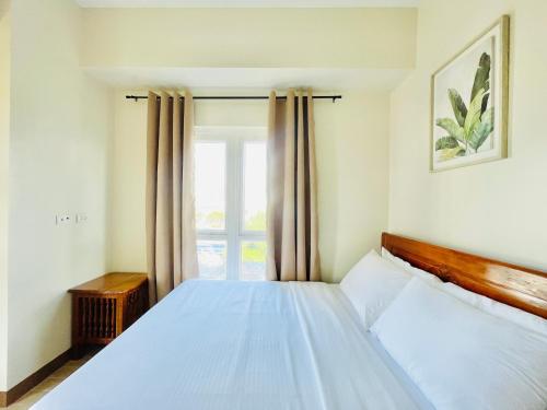 a bedroom with a white bed and a window at Saint Honore & Saint Dominique in Iloilo City