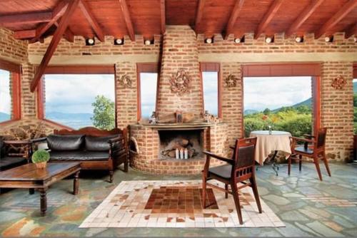 a living room with a brick fireplace and a table at Hotel Loggas in Kastoria
