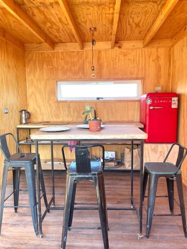 una cucina con tavolo, sedie e frigorifero rosso di Tiny house & SpA, casa de encuentros a La Ligua