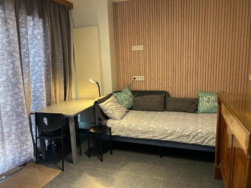a living room with a couch and a desk with a table at Dame Cerise in Wavre