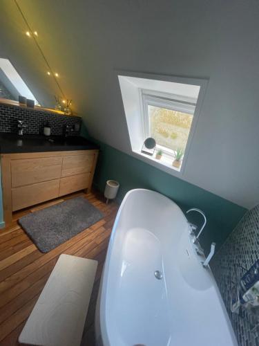 a bathroom with a white tub and a window at Propriété de charme avec piscine intérieure Lille in Marcq-en-Baroeul