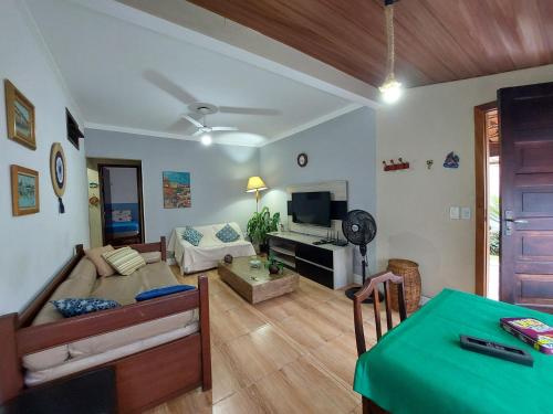 ein Wohnzimmer mit Sofa und Tisch in der Unterkunft Linda casa Rio das Ostras, ar condicionado, wifi, churrasqueira e garagem in Rio das Ostras