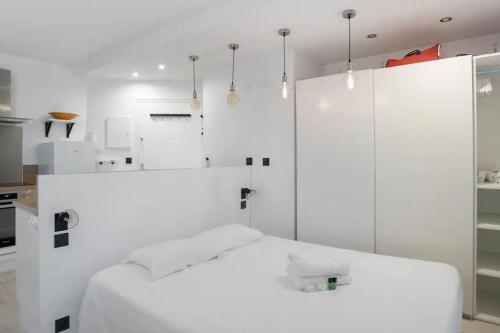 - une chambre blanche avec un grand lit blanc dans l'établissement Studio tout confort pour 4 pers, à Vanves