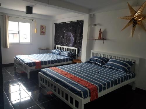 a bedroom with two beds and a star on the wall at Jay Jay Guesthouse in Bangkok
