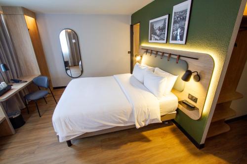 a hotel room with a large bed and a desk at Campanile Prime Paris 19 - La Villette in Paris