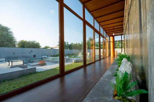 a room with large glass windows and a wooden floor at THE JAPANESE HOUSE by BRIDGE RETREATS in Ras al Khaimah