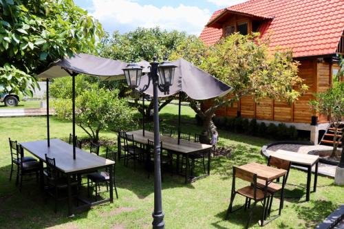 a group of tables with an umbrella and a street light at Molino de Café Cabañas Lodge in Chinchín Loma