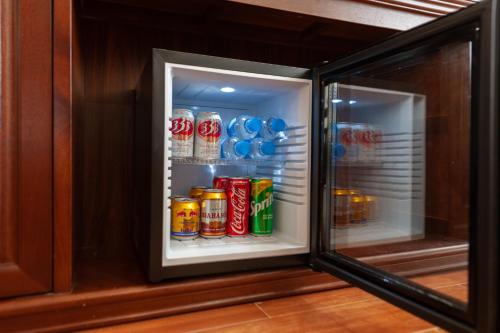 an open refrigerator filled with cans of soda at Sapa Passion Hotel & Spa in Sa Pa