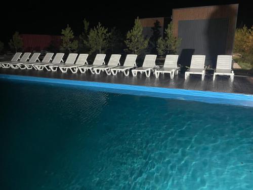 a group of chairs sitting next to a swimming pool at Atyrau Avenue in Vorobʼyëvka