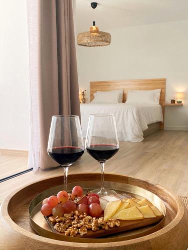 two glasses of wine and a tray of food on a table at Fuerte Calma Luxury Apartment Fuerteventura in La Oliva