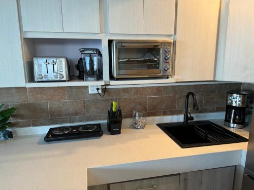 a kitchen with a counter top with a microwave at Aguada Beach Condos in Aguada