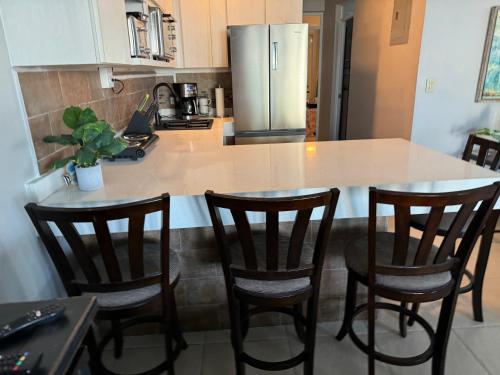a kitchen with a counter with four chairs and a island at Aguada Beach Condos in Aguada