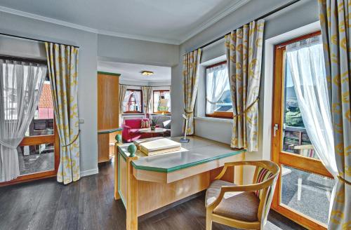 a home office with a desk and windows at DIANA Naturpark Hotel - Partnerbetrieb von "Oberstaufen PLUS GOLF" in Oberstaufen